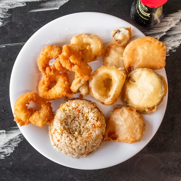A white plate with fried calamari, tempura vegetables, and a scoop of fried rice.